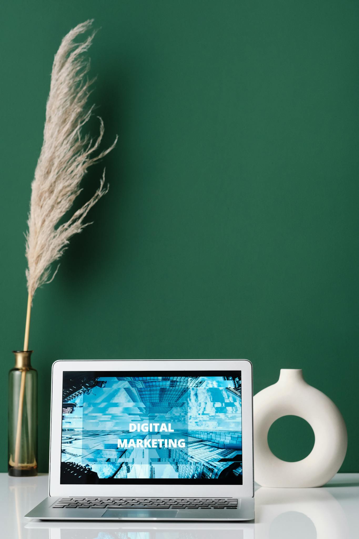 Laptop displaying digital marketing on screen with decorative items on a desk.